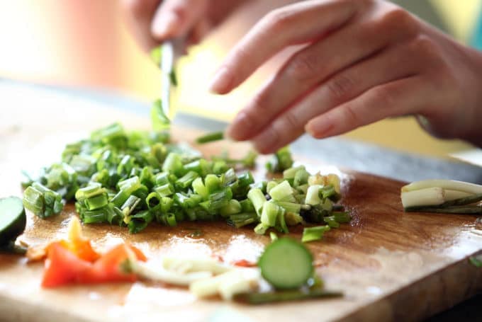 Hands chopping green onions